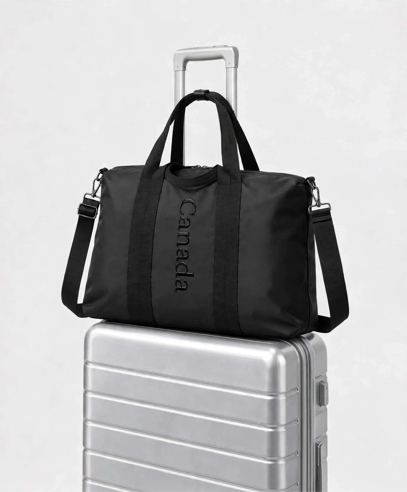 Nordin sleeve bag hanging on the handle of a silver suitcase